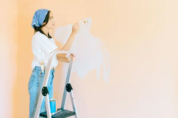 Interior painting in Madison: painter on a stepladder rolling a wall